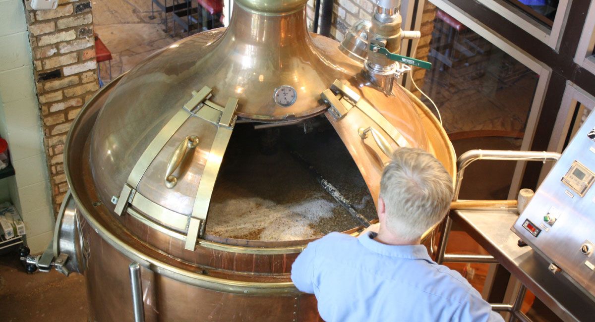 Person Inspecting Brewing Kettle